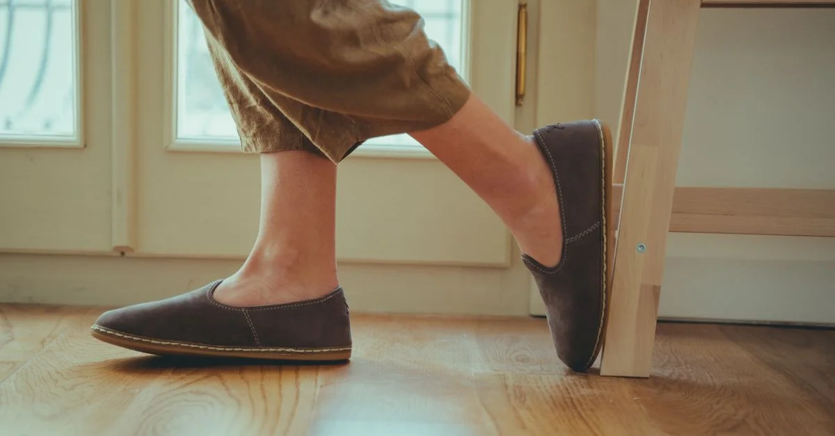 Acercamiento de mujer con mocasines y pantalones casuales, en un estilo relajado y en interiores.