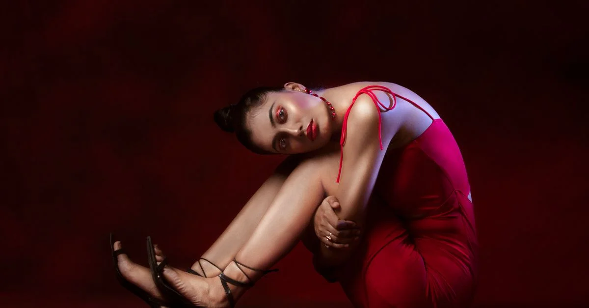 Retrato sofisticado de una mujer en un vestido rojo contra un fondo rico.